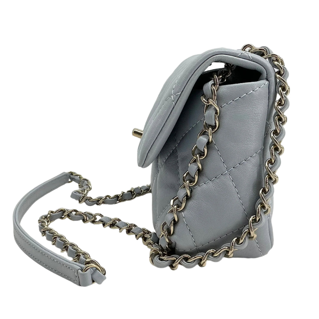 Chanel Mini Chain Around Flap Bag in quilted grey calfskin leather with chain strap, showcasing modern elegance and craftsmanship.