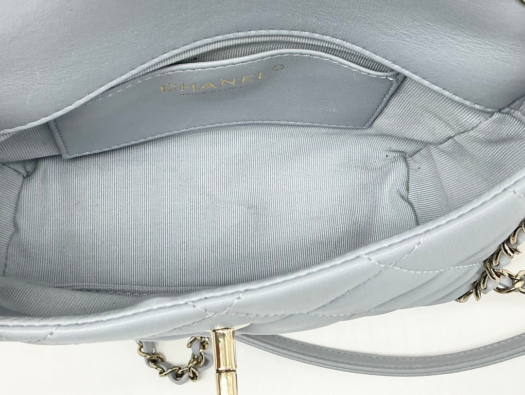 Interior view of Chanel Mini Chain Around Flap Bag featuring gray quilted lining and logo detailing.