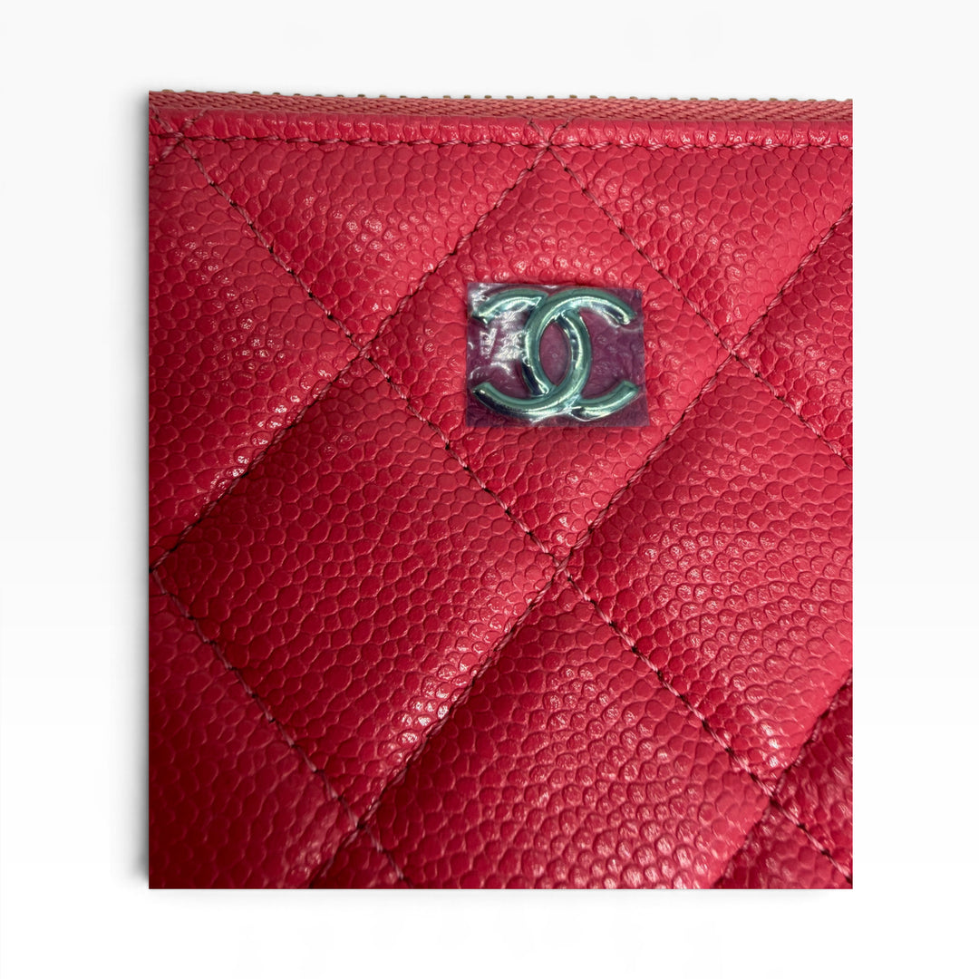 Close-up of CHANEL interlocking CC emblem on red quilted caviar grained leather