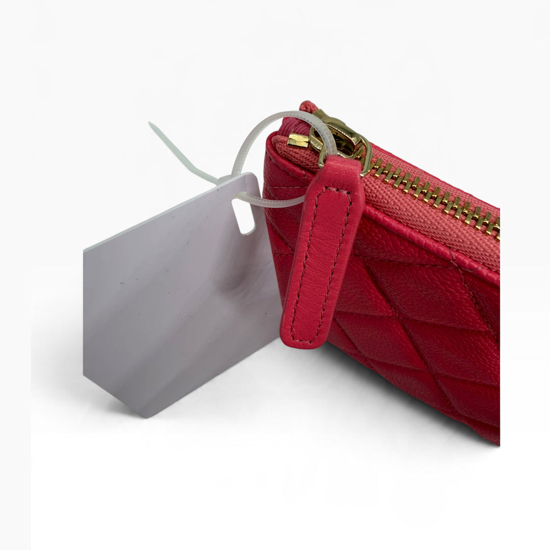 Red leather zipper pull and gold tone zipper hardware detail of CHANEL Mini O-Case pouch