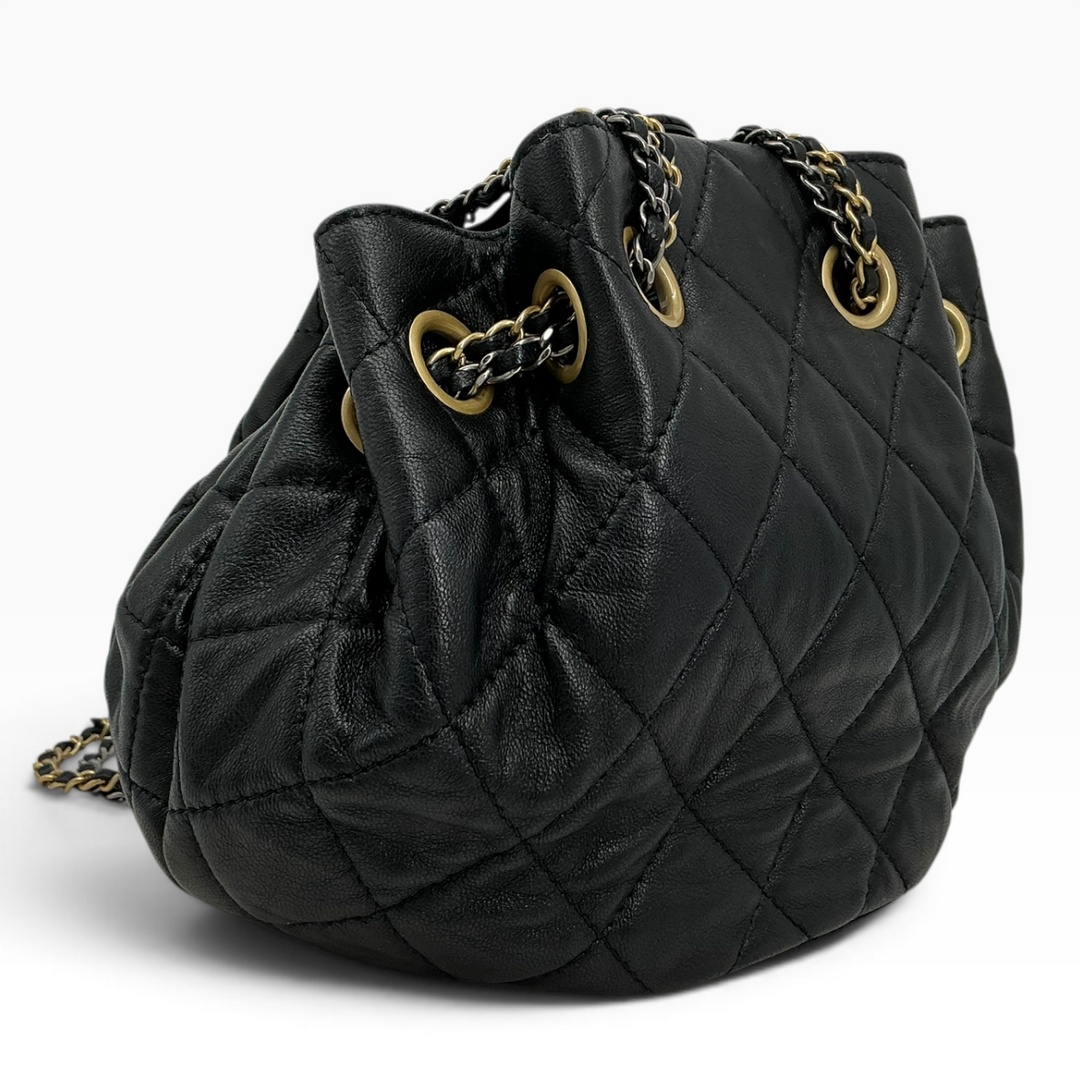 Chanel Small 19 Bucket Bag black angled view showing quilted calfskin and gold-tone chain hardware back of bag.