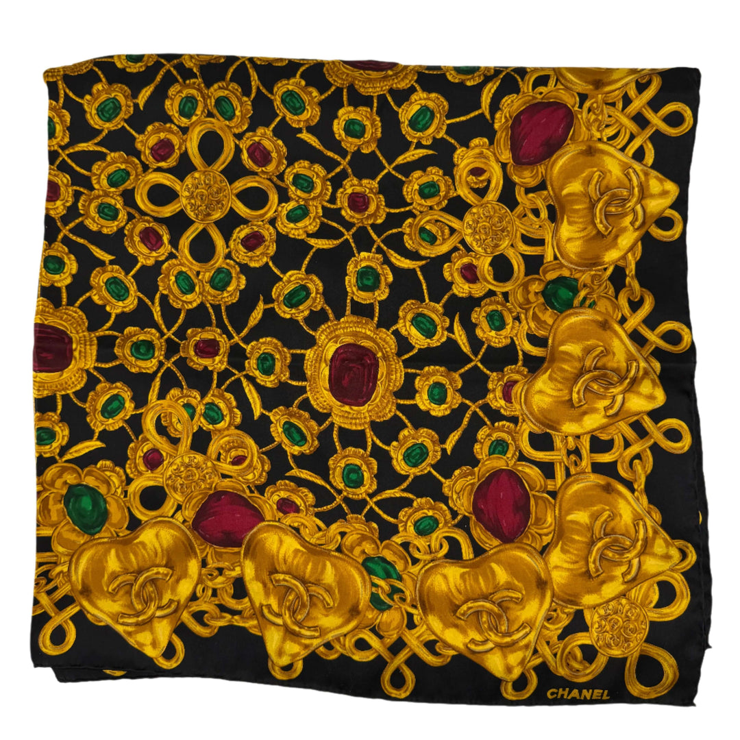CHANEL vintage black and gold silk scarf featuring ornate jewelry chain print with emerald and ruby accents.