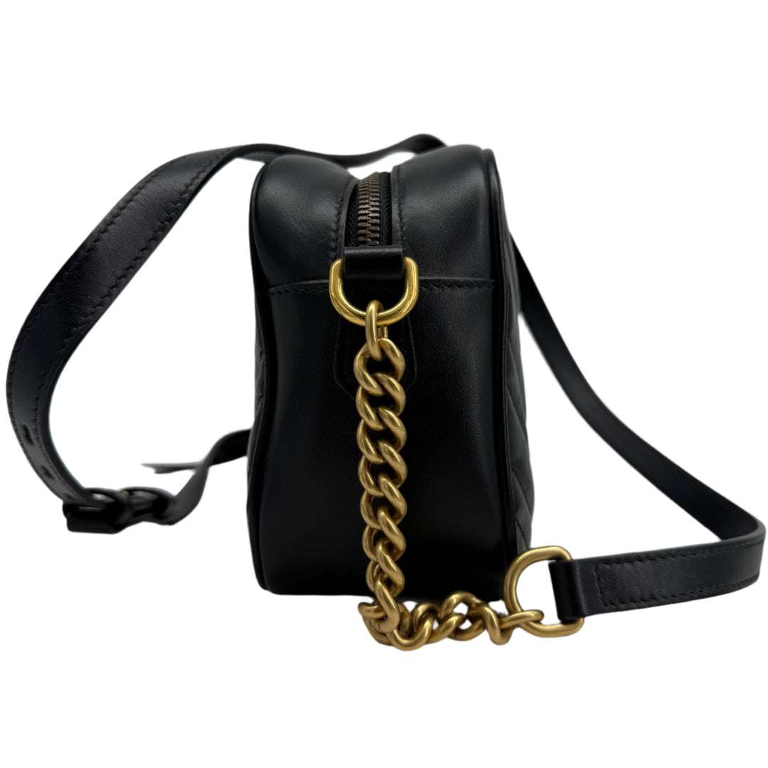 Side view of Gucci GG Marmont Small Shoulder Bag in black matelassé calfskin with antiqued gold chain strap.