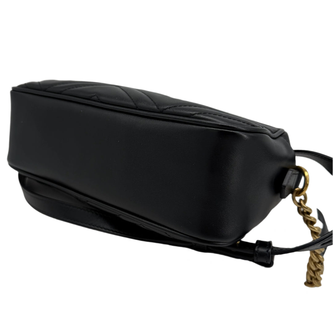 Gucci GG Marmont Small Shoulder Bag in black matelassé calfskin with gold chain, showcasing its sleek profile.