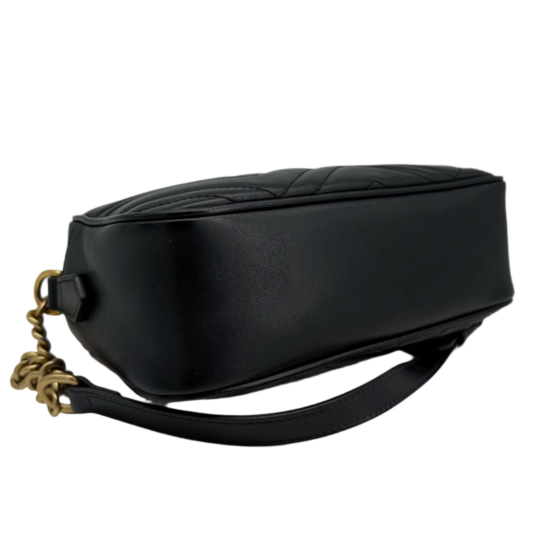 Gucci GG Marmont Small Shoulder Bag in black matelassé calfskin showing side view with antiqued gold chain.