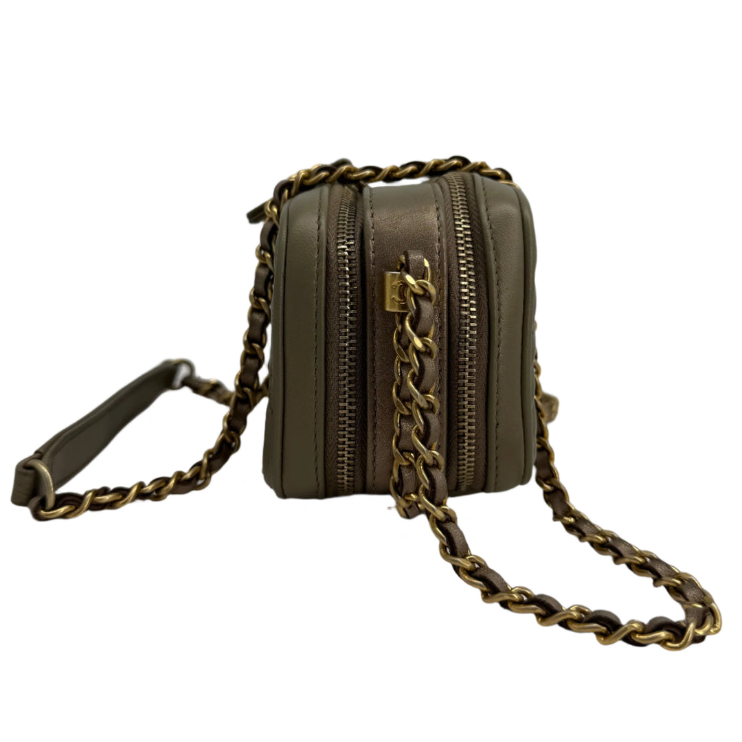 Olive green zippered handbag with chain strap, showcasing luxury design and functionality.