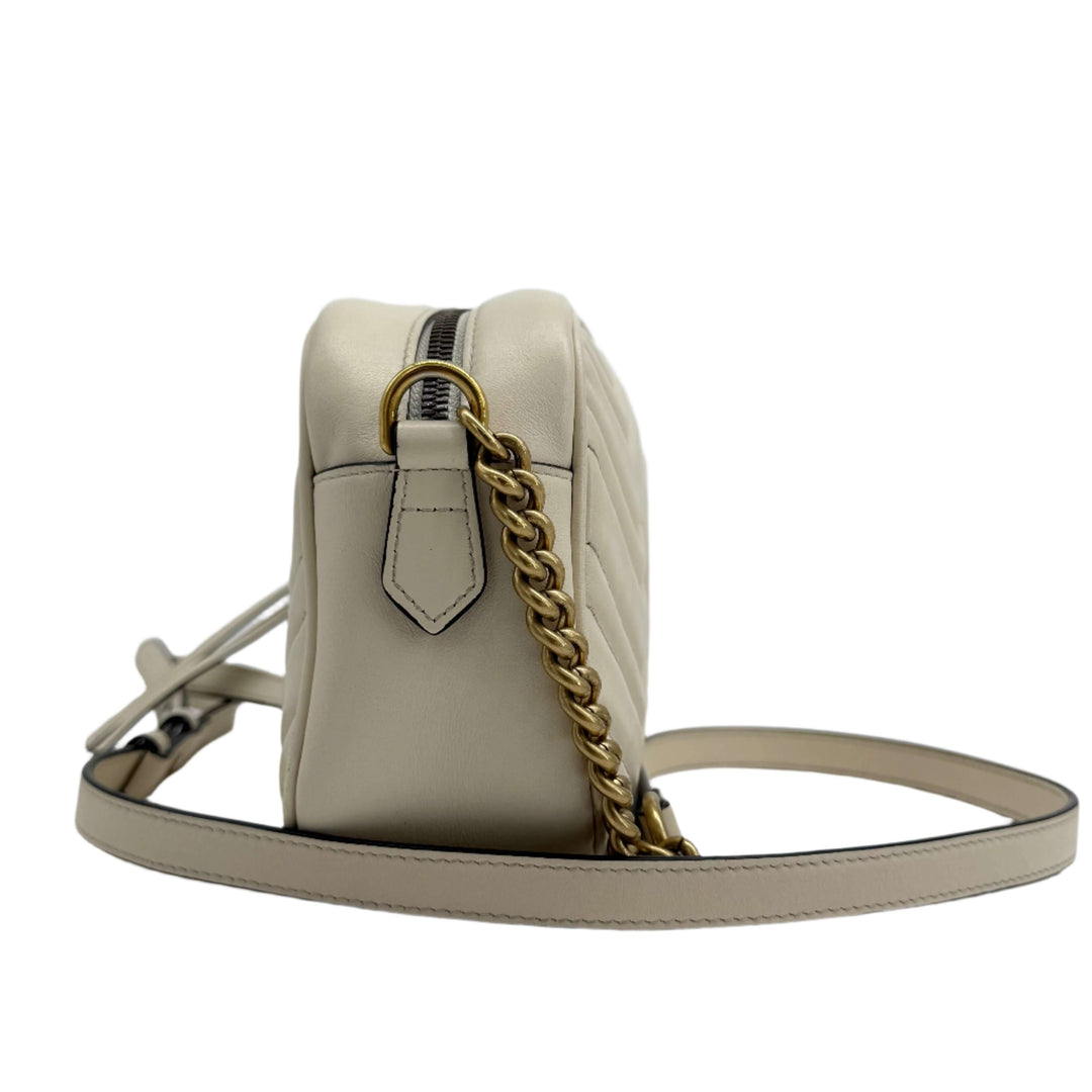 Gucci GG Marmont Small Shoulder Bag side view showcasing off-white calfskin leather and antiqued gold chain strap.