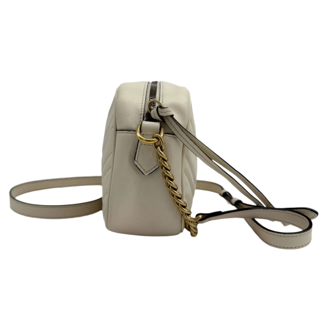 Gucci GG Marmont Small Shoulder Bag in white matelassé calfskin showcasing antiqued gold chain and crossbody strap.