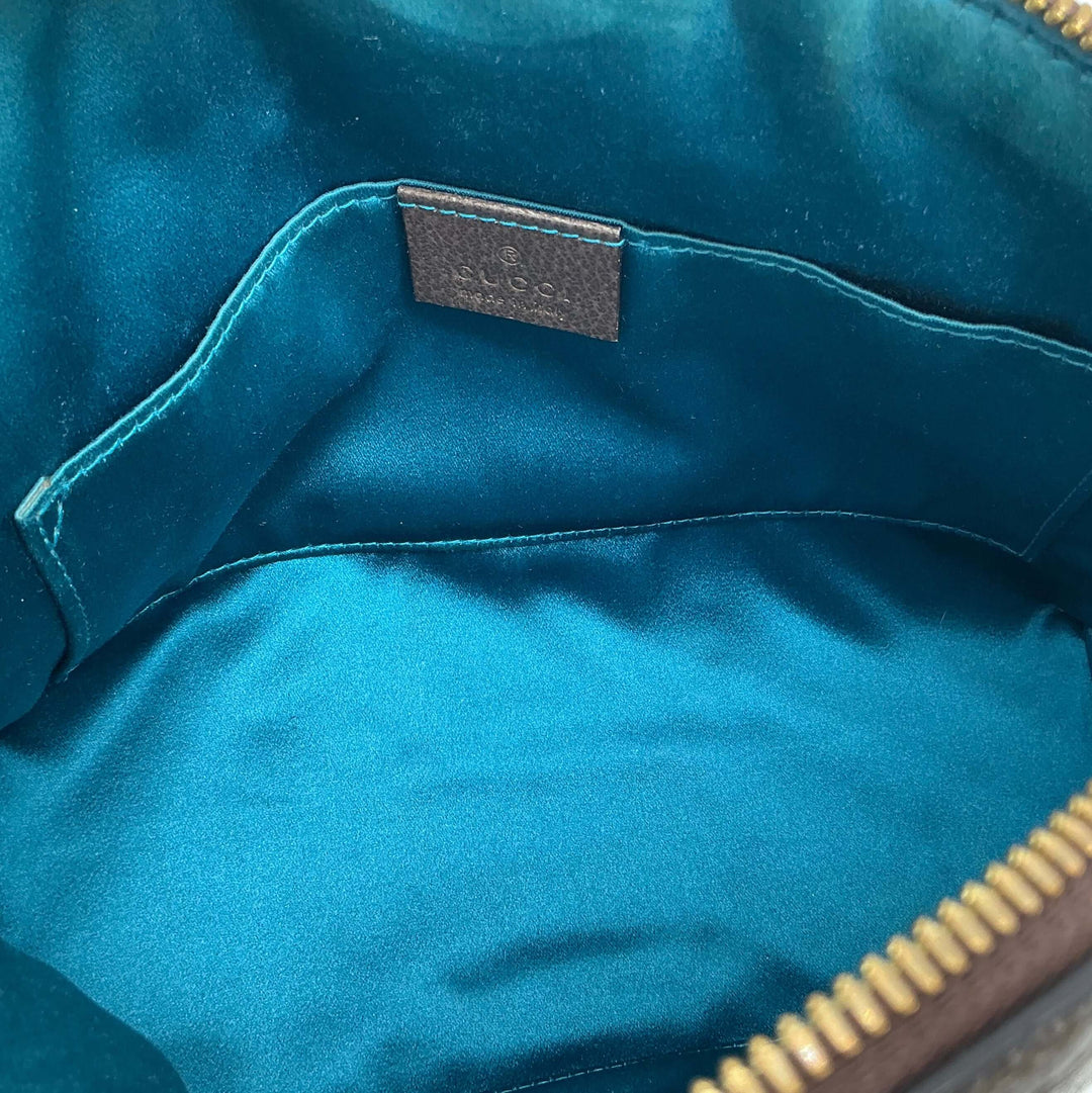 Interior view of Gucci GG Supreme Dome Shoulder Bag featuring teal lining and leather label.