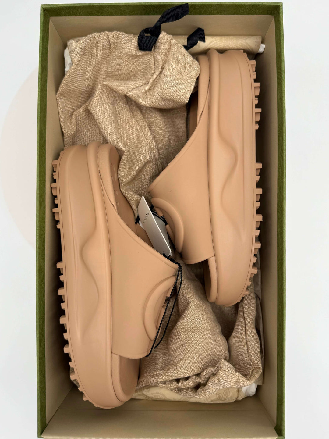 Gucci Interlocking G platform slide sandals in Vintage Camel rubber, displayed inside a green box with soft cloth.