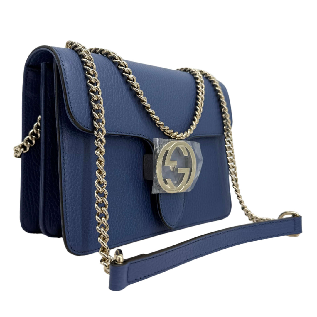 Gucci Interlocking G Small Shoulder Bag in dollar calfskin leather with gold-tone chain strap and signature GG turn-lock.