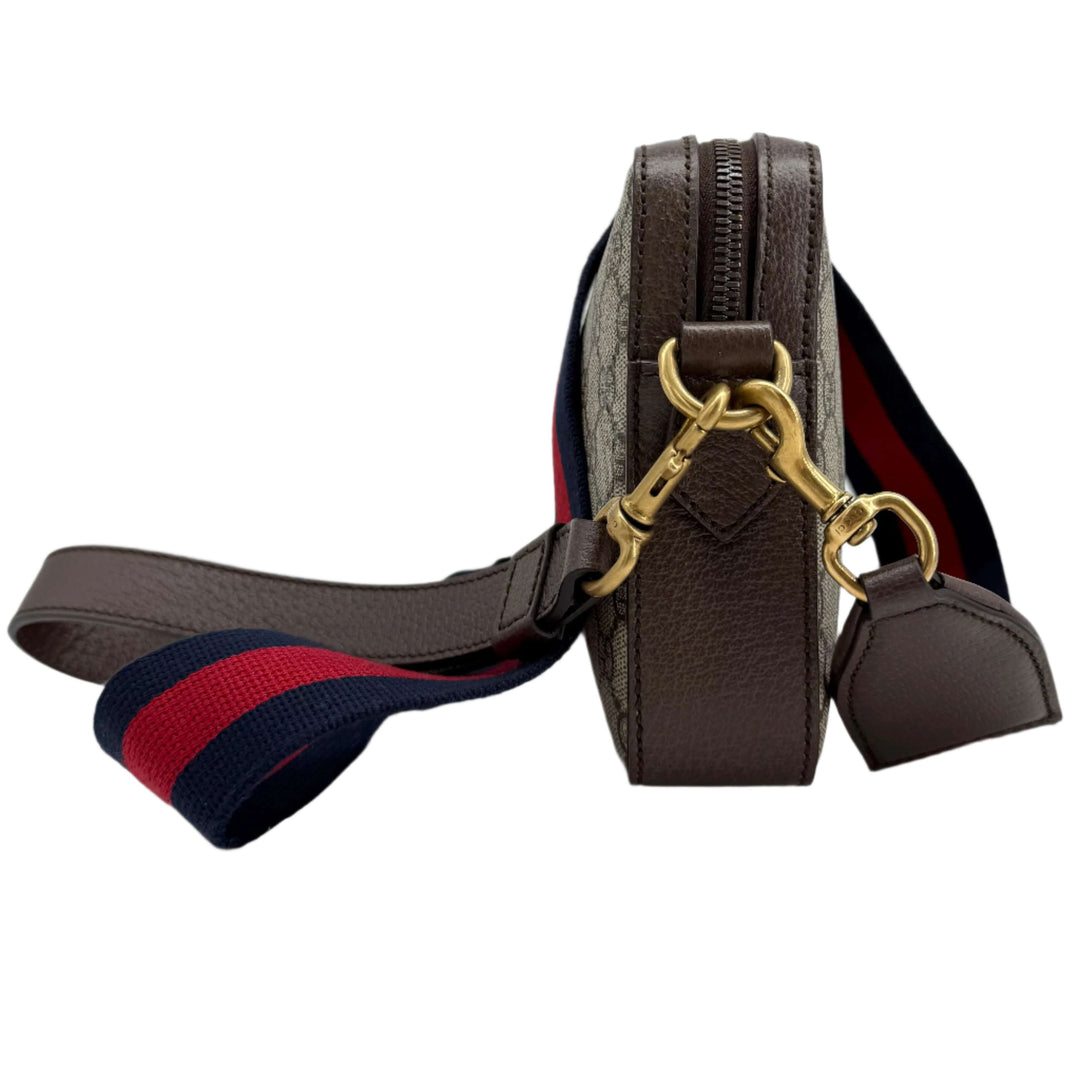 Gucci Ophidia Crossbody Bag side view showcasing GG Supreme canvas, web strap, and gold hardware.