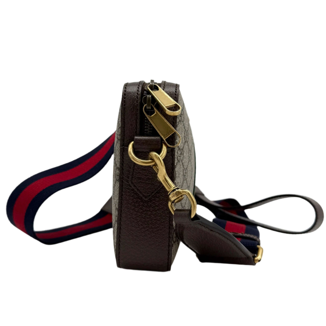 Side view of Gucci Ophidia Crossbody Bag showcasing GG Supreme Canvas, Web strap, and gold hardware details.