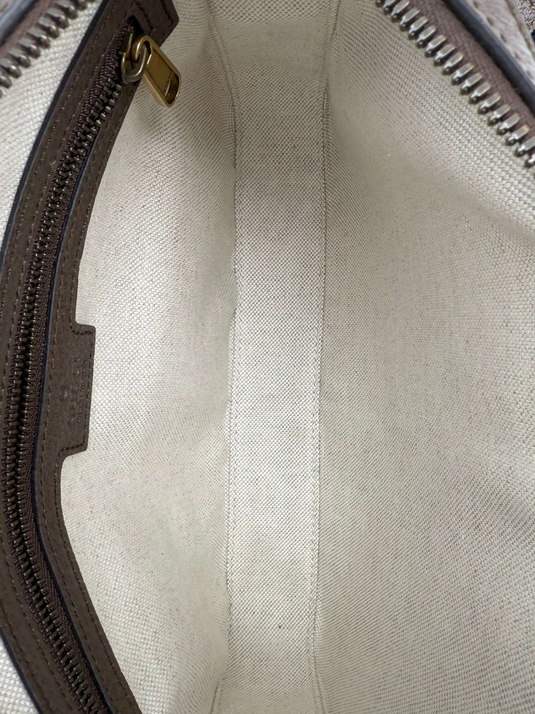 Interior view of the Gucci Ophidia Crossbody Bag featuring beige lining and zipper compartment.