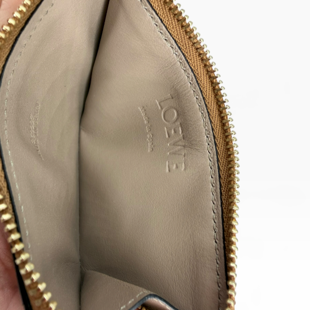 Interior of LOEWE coin cardholder showing smooth leather lining, embossed logo and metal zipper
