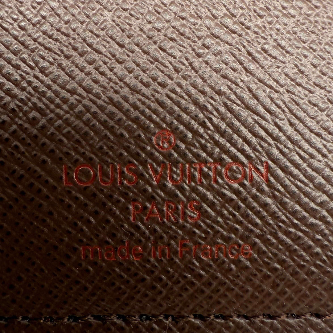 Close-up of Louis Vuitton logo embossed on brown leather, showcasing 'Made in France' craftsmanship.