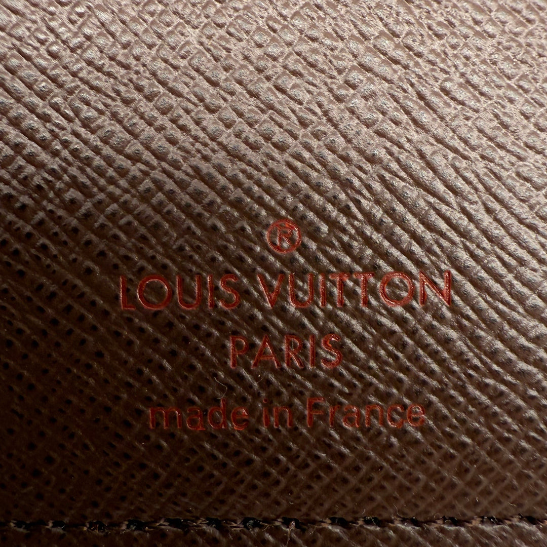 Close-up of Louis Vuitton signature logo and 'made in France' detail on Damier Ebene coated canvas.