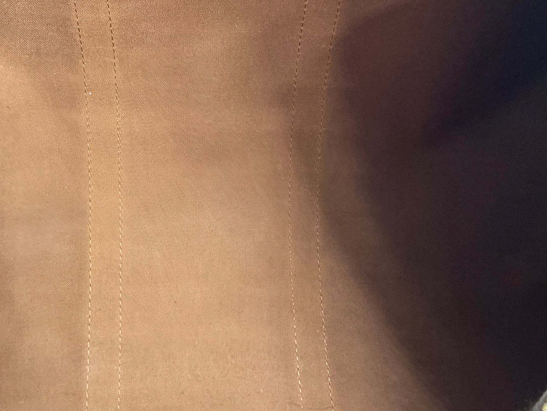 Close-up of the interior lining of a luxury bag, showcasing smooth leather and detailed stitching.