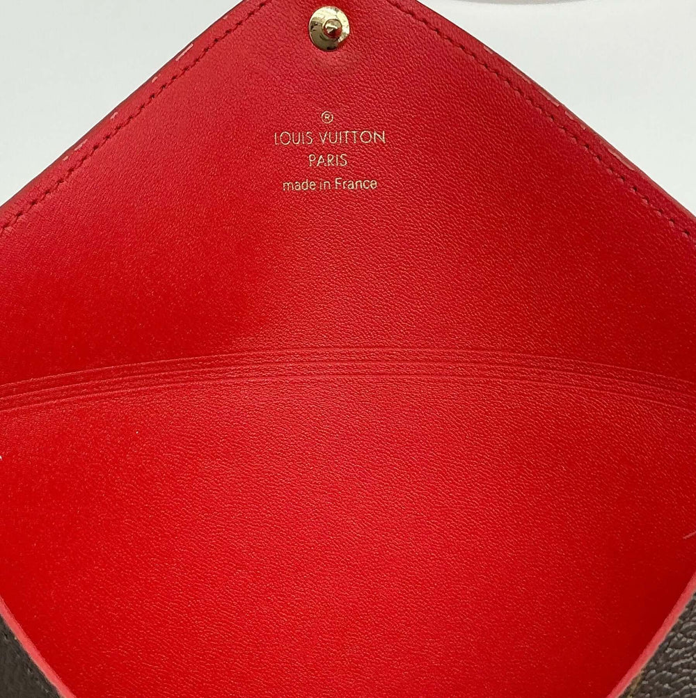 Inside view of the Louis Vuitton Medium Kirigami Pochette Insert, featuring a vibrant red leather interior and gold-tone branding.