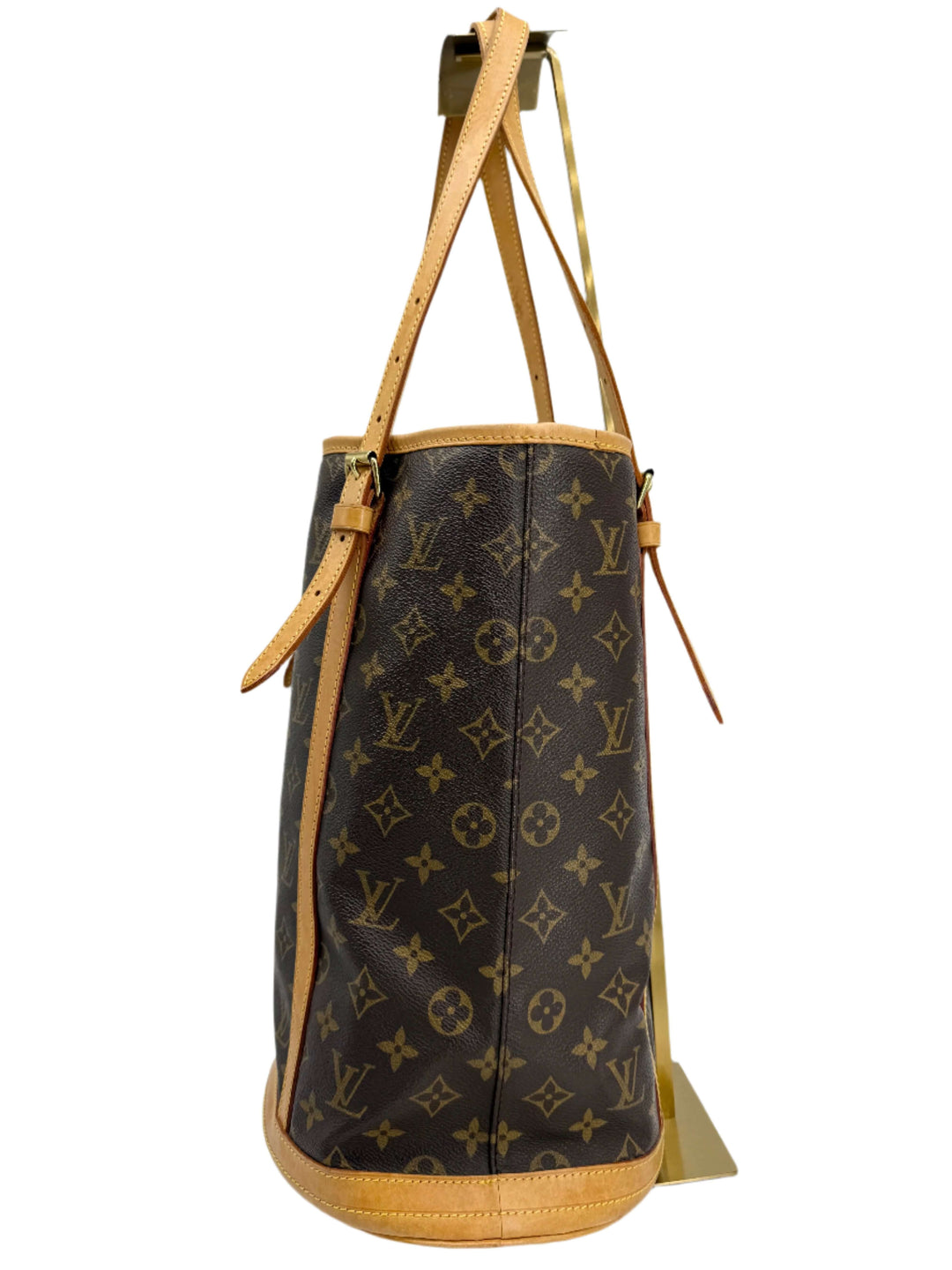 Side view of Louis Vuitton Monogram Bucket Bag in coated canvas with natural leather trim and shoulder straps.