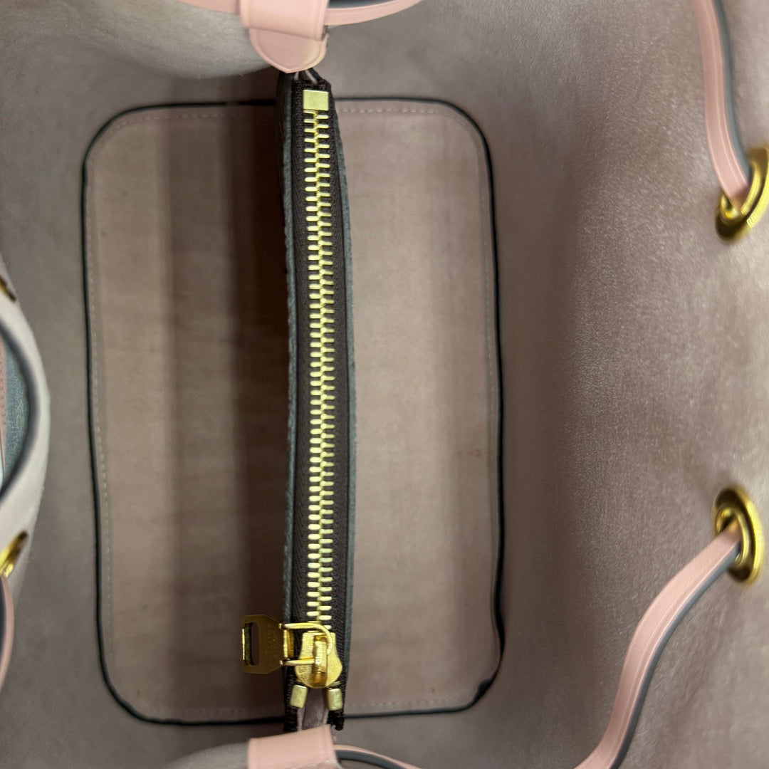 Interior view of Louis Vuitton Rose Poudre bucket bag featuring a gold zip pocket and soft lining.