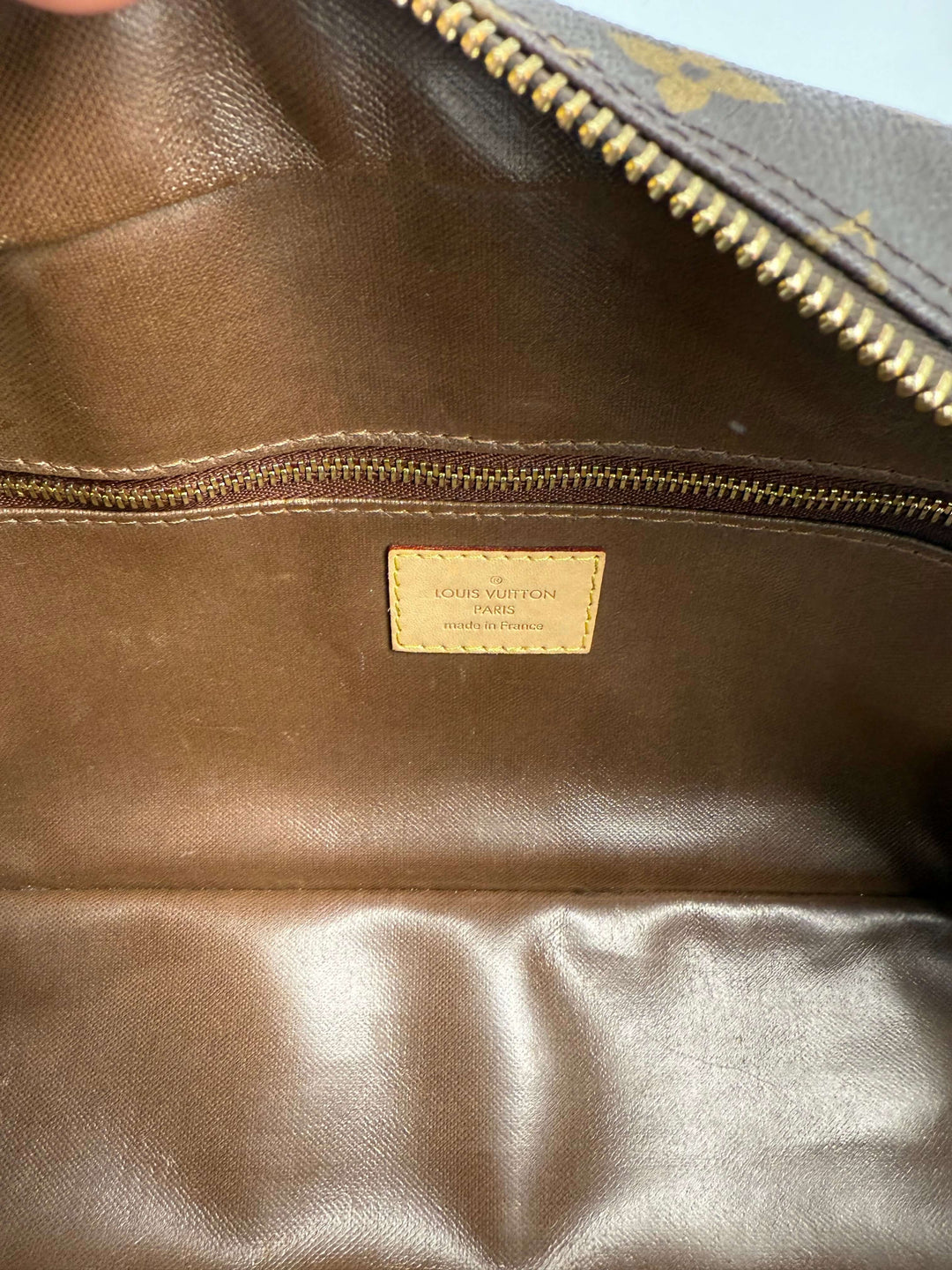 Interior view of Louis Vuitton Monogram Toiletry Bag 25 showcasing its signature canvas and leather label.