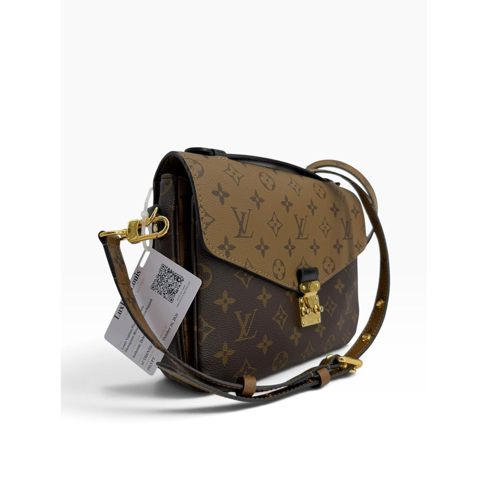 Front angled view of Louis Vuitton Pochette Metis Monogram Reverse crossbody bag