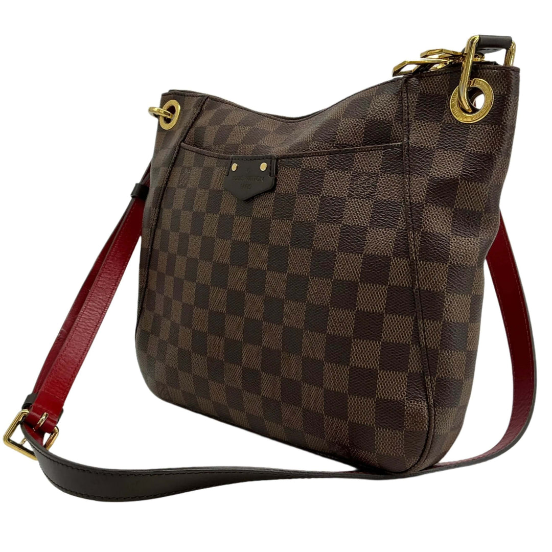 Louis Vuitton South Bank Besace shoulder bag in Damier Ebene canvas with red strap, showcasing classic elegance and functionality.