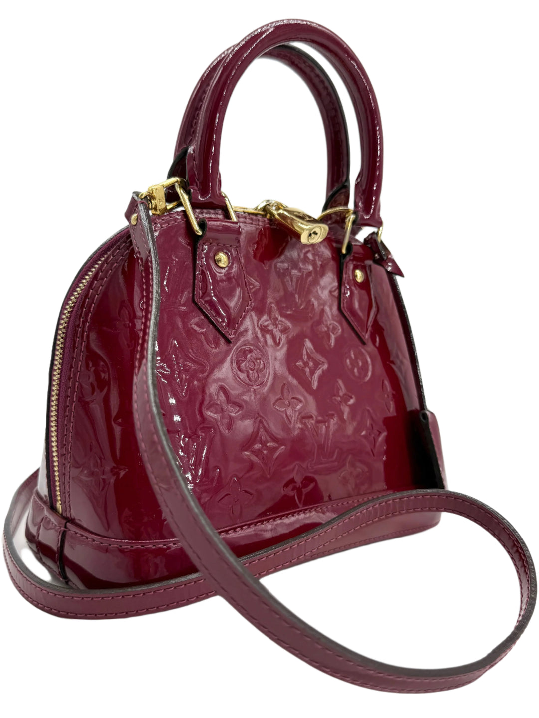 Louis Vuitton Vernis Alma BB bag in magenta patent leather with gold hardware and rolled handles.